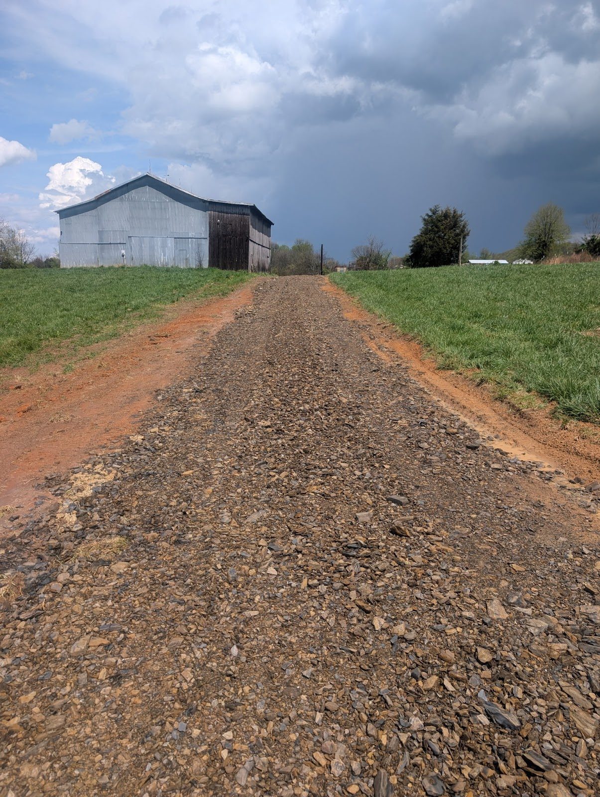 New gravel driveway leading up to a barn