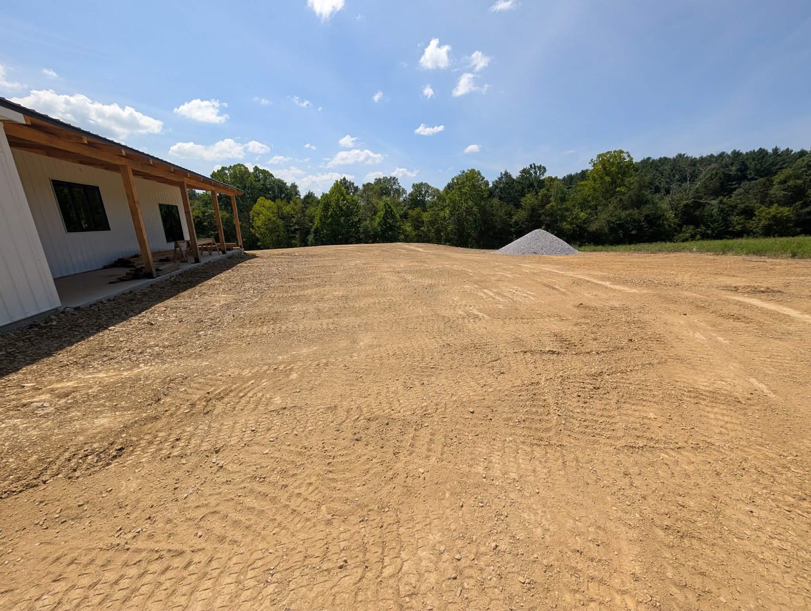 Graded lot beside a new home with a gravel pile